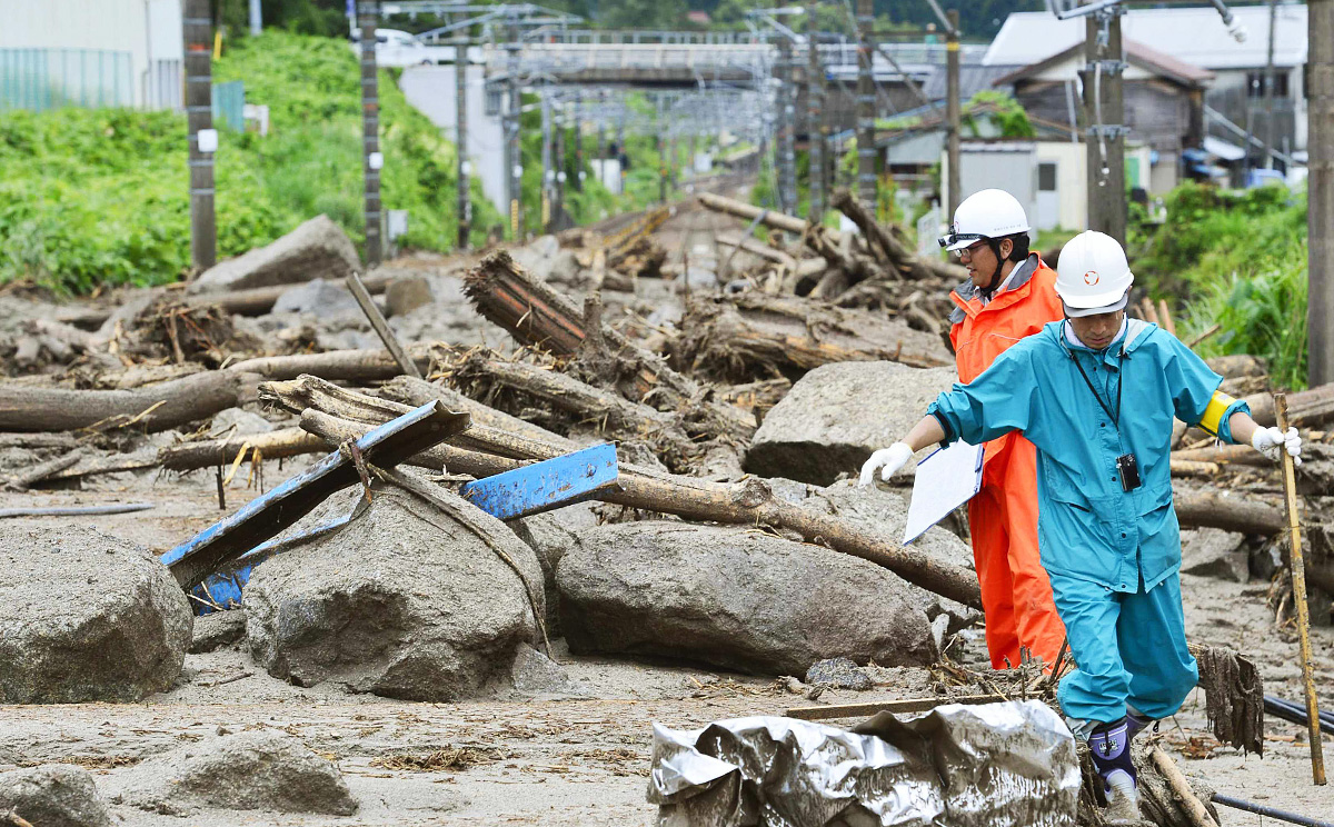 Workers walk among debris at an area affected by landslide caused by heavy rains due to Typhoon Neoguri in Nagiso. Photo: Reuters