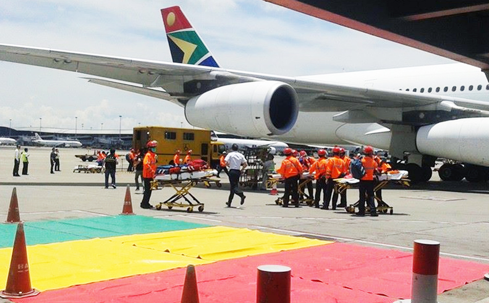 South African Airways flight 286 stands on the tarmac as emergency crews unload the injured passengers. Photo: SCMP