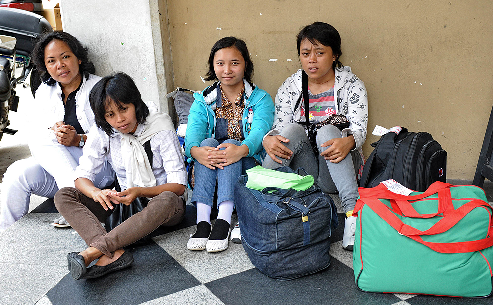 Newly arrived domestic helpers from Indonesia wait for their transportation to a maid agency after going through medical check in Singapore in this file photograph. Photo: AFP