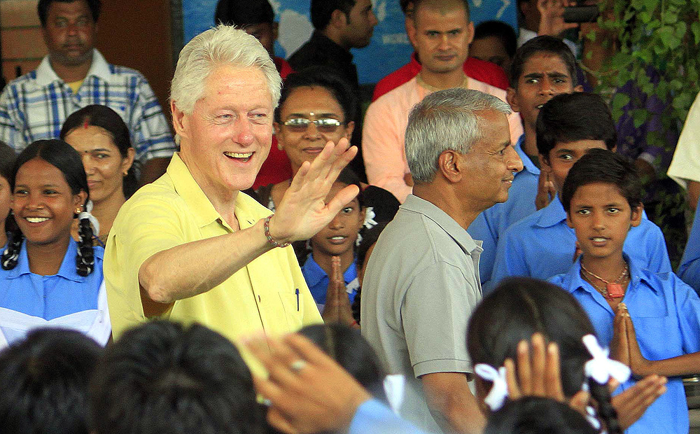 Former US president Bill Clinton greets students as he visits a government school in Jaipur, India on Wednesday. Photo: Xinhua