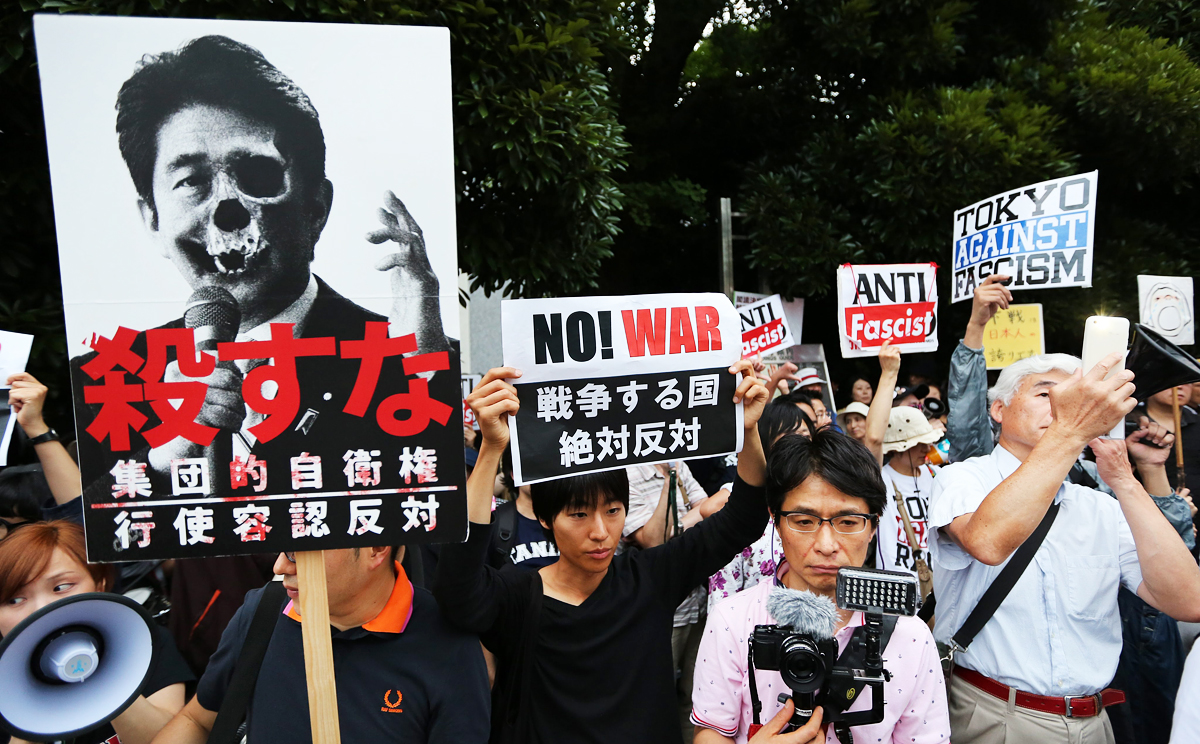 Protesters hold placards and shout anti-government slogans during a rally against Japanese Prime Minister Shinzo Abe's collective self-defense policy which was approved on July 1, 2014. Photo: EPA