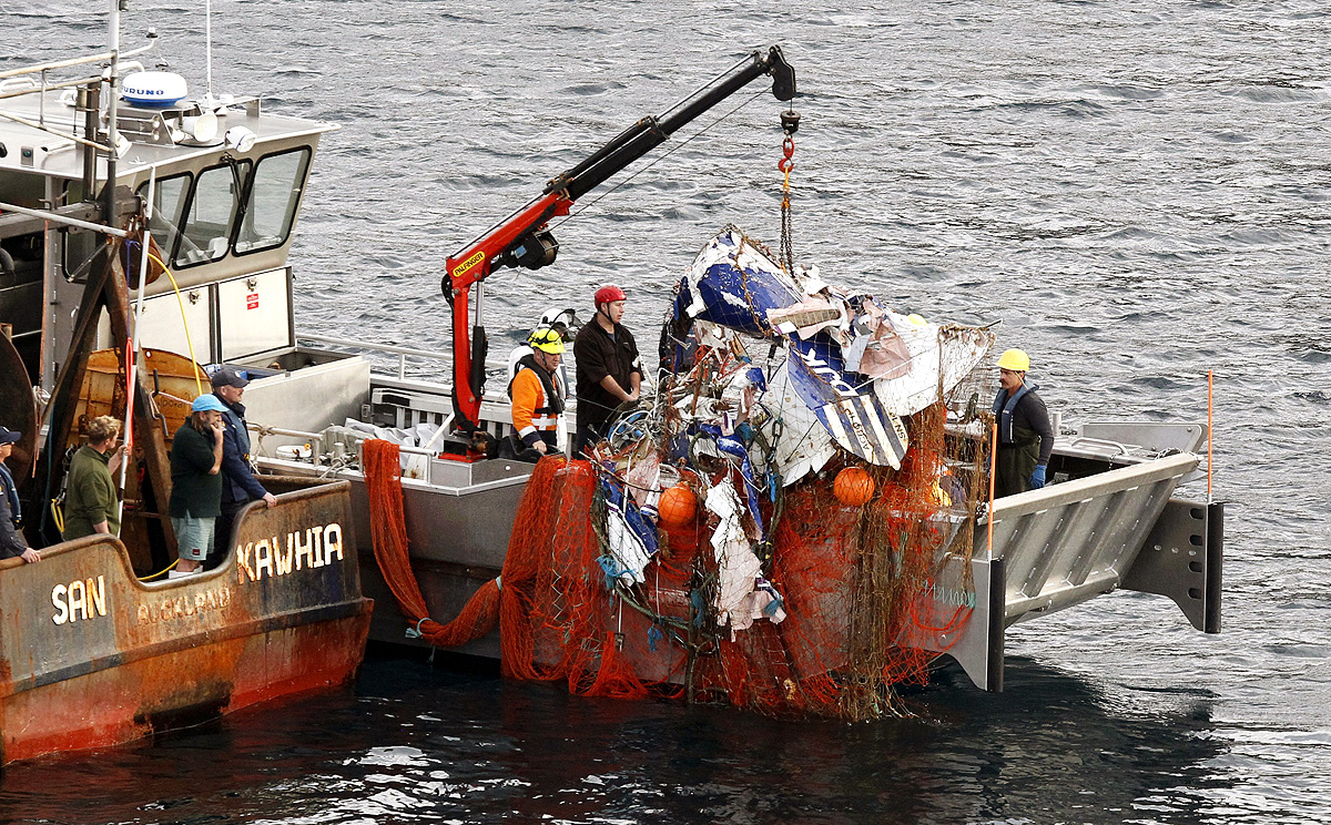 The wreckage of a small plane is hauled onto a fishing trawler after becoming caught in its nets near Auckland, New Zealand, on Thursday. Photo: AP