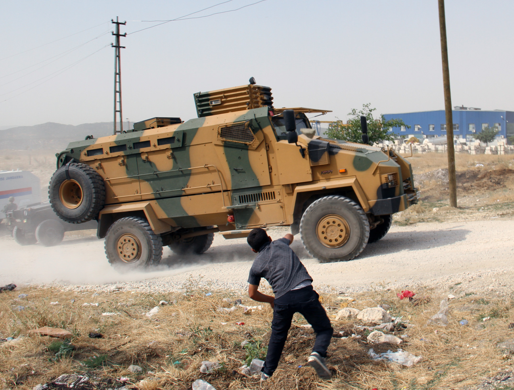 A man stones a Turkish military vehicle outside Lice, Diyarbakir, Turkey on August 19. Photo: AP