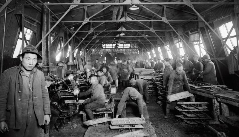 Members of the Chinese Labour Corps carryout riveting work at the Tank Corps Central Workshops, in France, during the first world war.