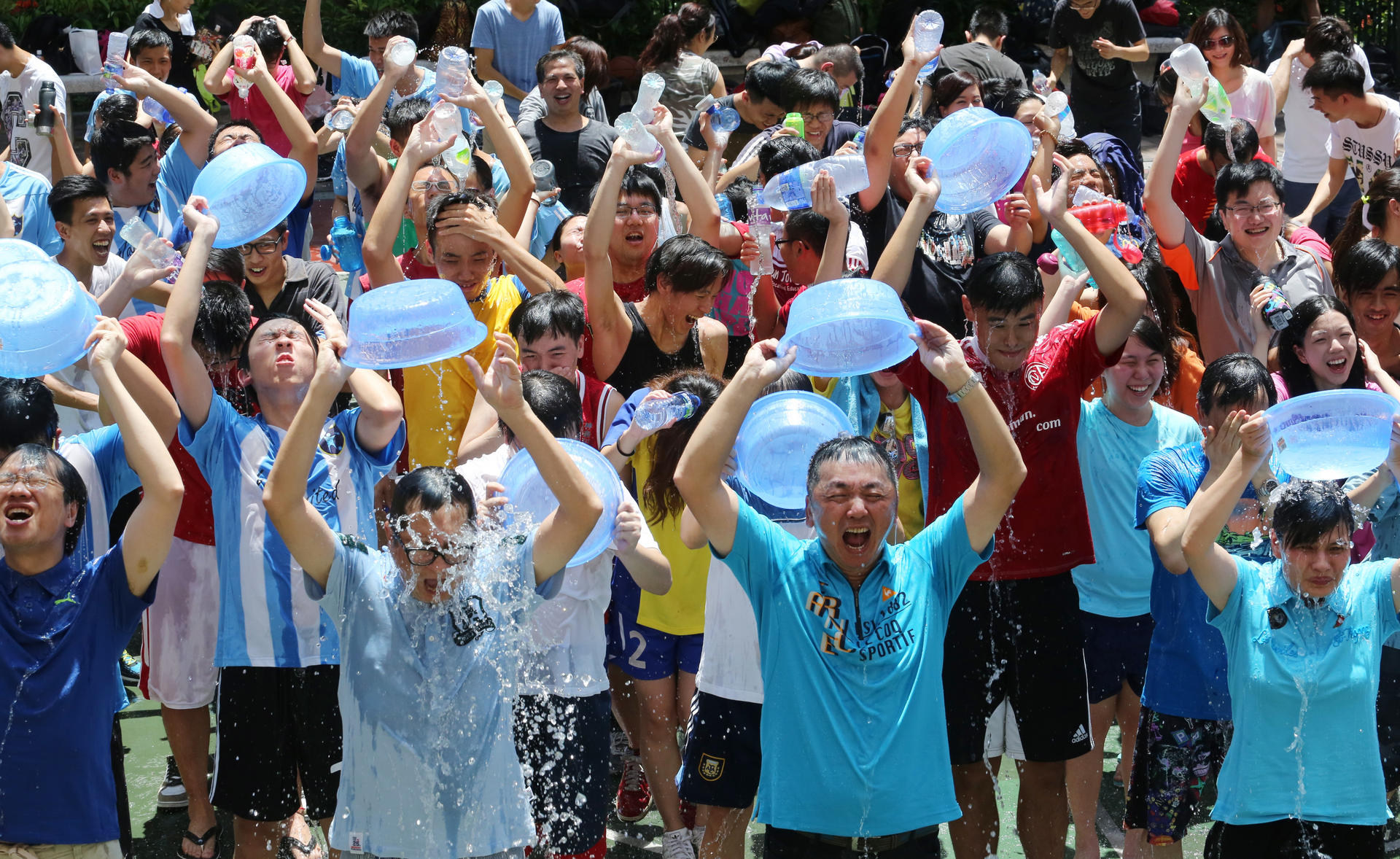 A few of the more than 200 participants in the city’s biggest Ice Bucket Challenge drench themselves with icy water at a park in Jordan yesterday. Photo: Felix Wong