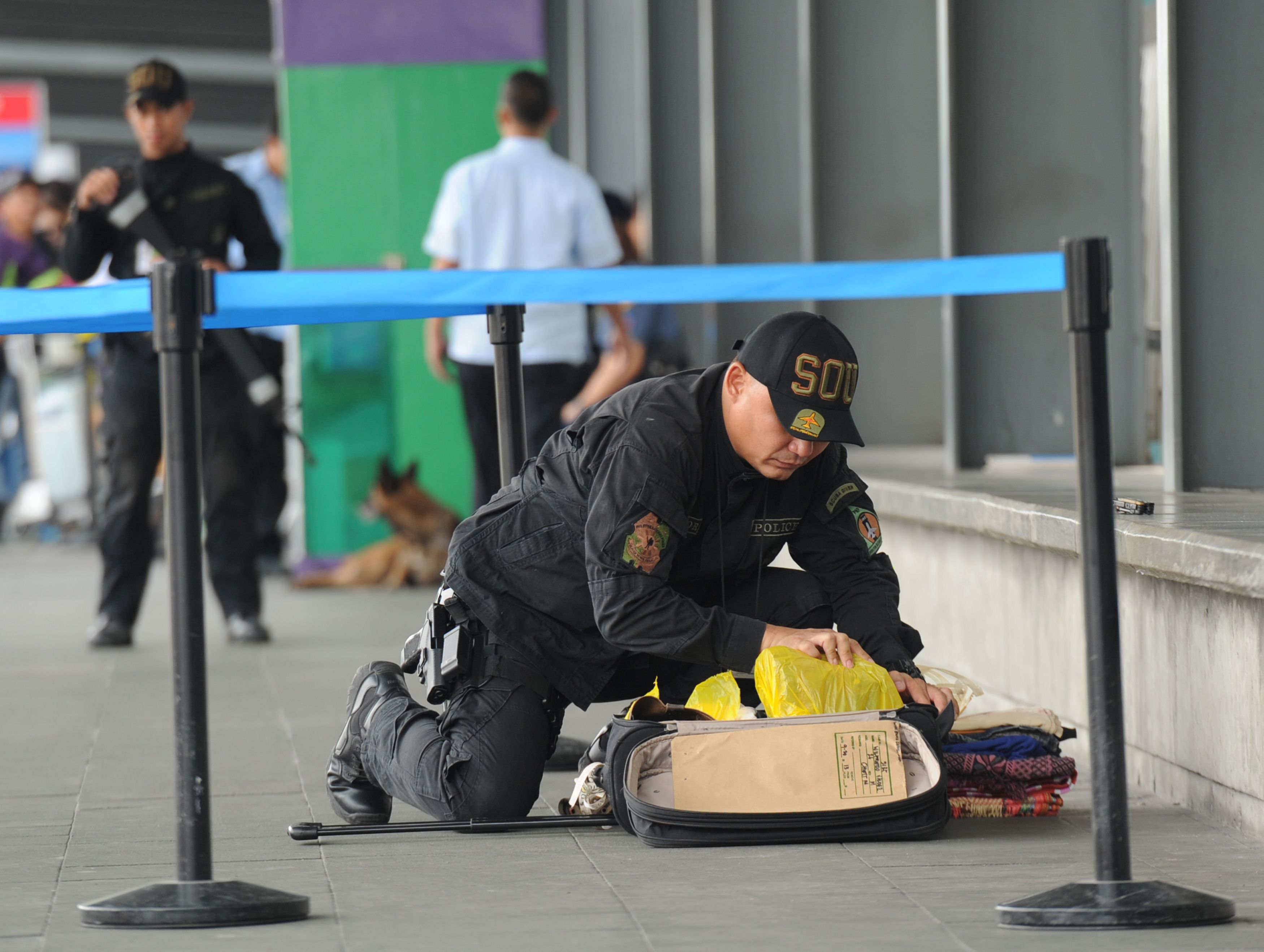 A Philippine police bomb disposal unit member inspects abandoned luggage at Manila's international airport. Photo: AFP