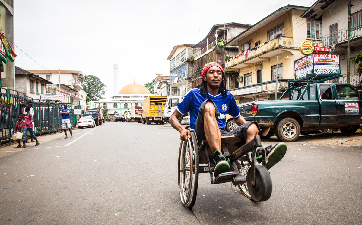 A man travels along a street in his wheelchair as the three-day lockdown to prevent the spread on the Ebola virus in Freetown, Sierra Leone comes to an end on Sunday. Photo: AP