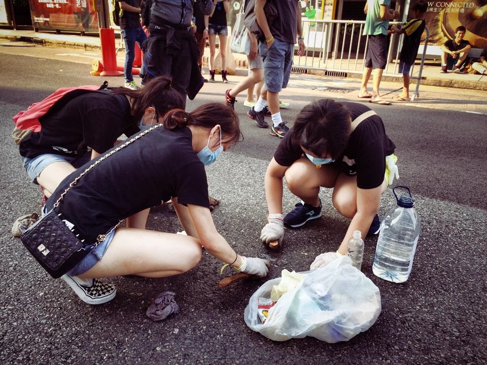 Volunteers are seen carrying bulging plastic bags and cleaning the street. Photos: Jason Y Ng