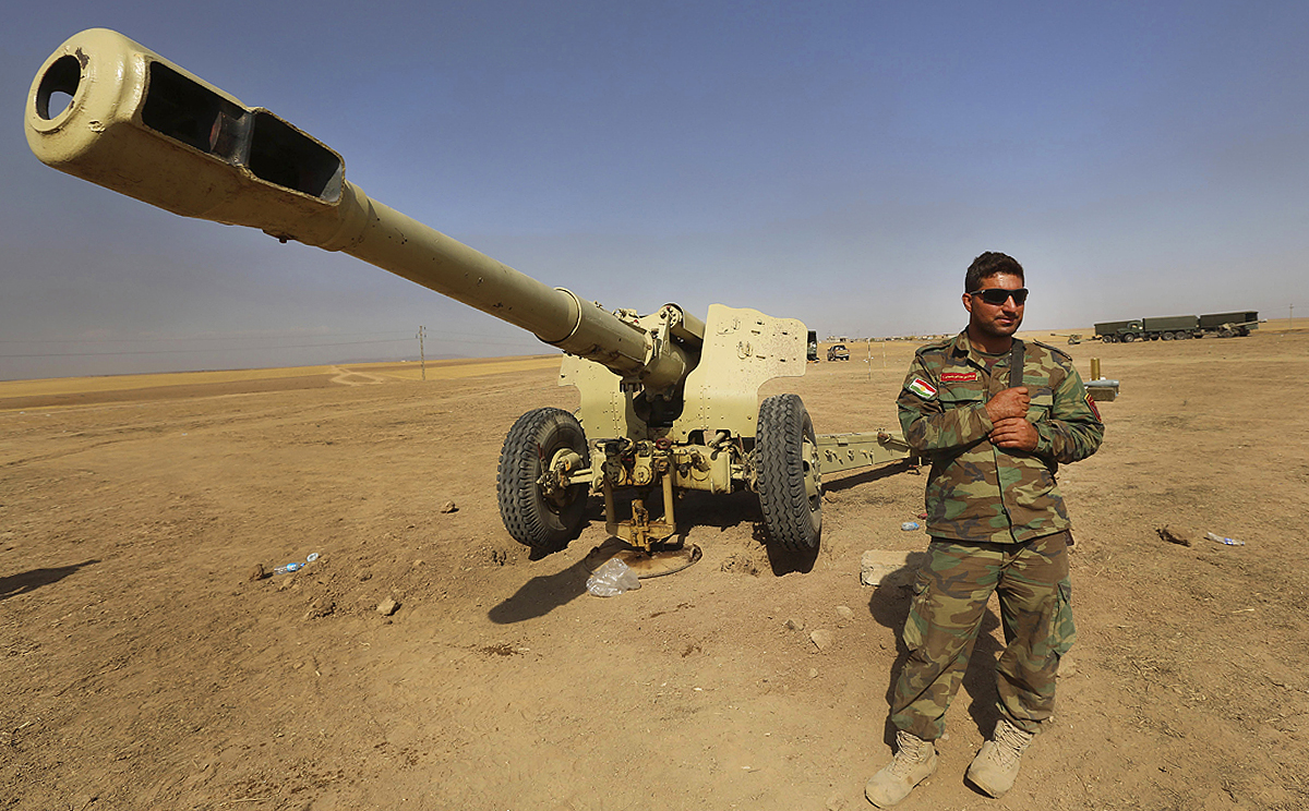 A Kurdish peshmerga fighter stands next to an outdated cannon in Mahmoudiyah, Iraq on Wednesday. Photo: AP