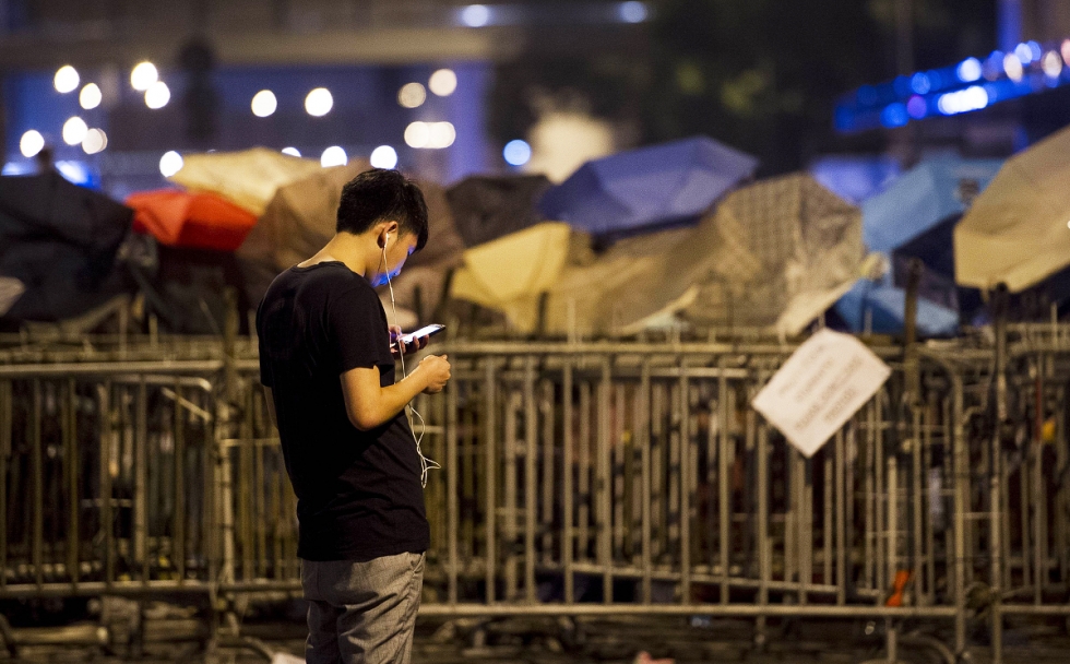 A pro-democracy demonstrator checks his phone in Hong Kong. WeChat is reportedly blocking messages about the protests. Photo: AFP