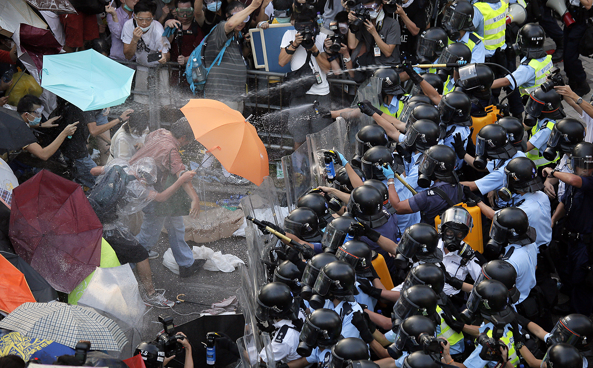 Police use pepper spray against protesters outside government headquarters in Hong Kong on Sunday. Photo: Vincent Yu