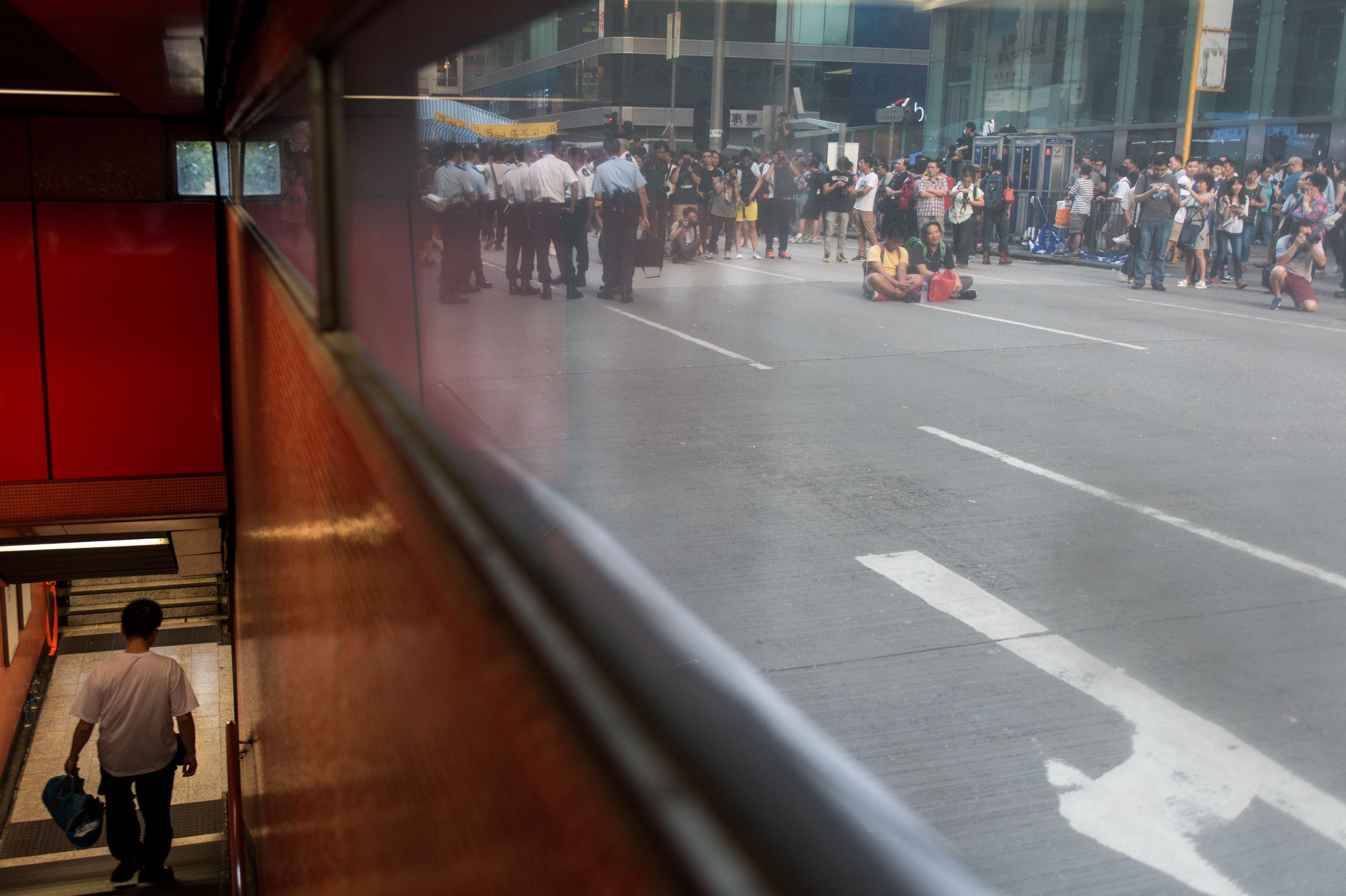 A commuter walks down a staircase leading to the MTR train at Mong Kok station, while protesters continue their sit-in outside. Photo: AFP