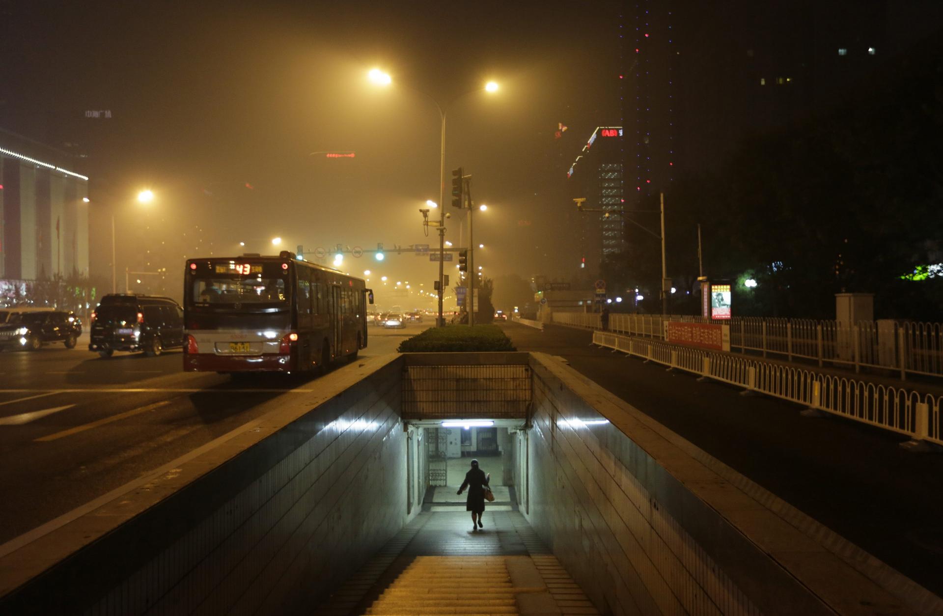 A woman walks through an underground passage on a hazy night in central Beijing as smog chokes the city. Photo: Reuters