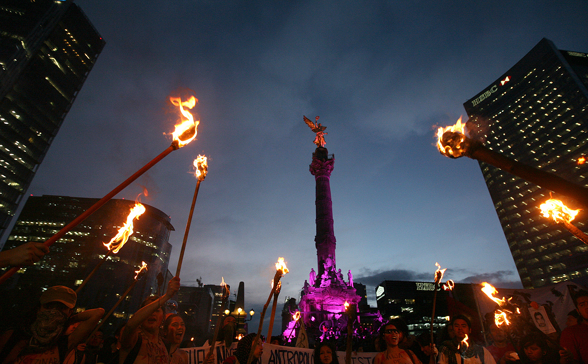 Demonstrators hold torches in front of the Independence Monument in Mexico City on Wednesday during a march in protest over the disappearance of 43 students from the Iguala teachers college. Photo: Associated Press
