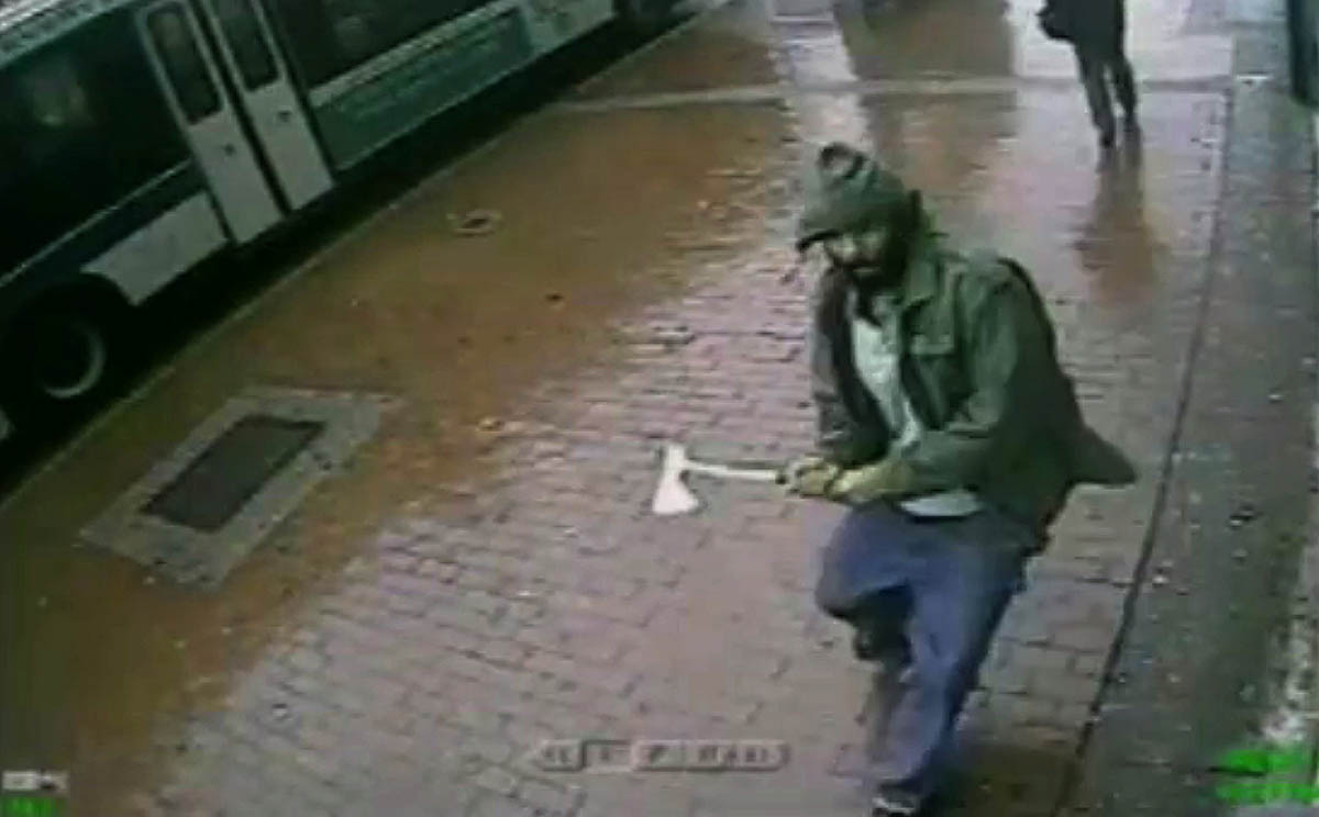 An unidentified man approaches police officers with a hatchet on Thursday in this screengrab taken from video provided by the New York Police Department. Photo: AP