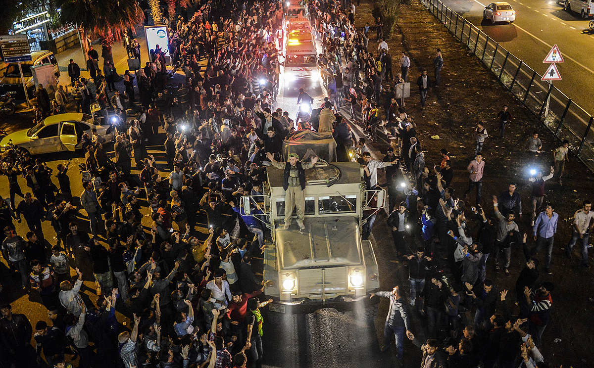 Kurds in Turkey greet peshmerga troops travelling in a convoy towards the Syrian border town of Kobane on Wednesday. Photo: AFP