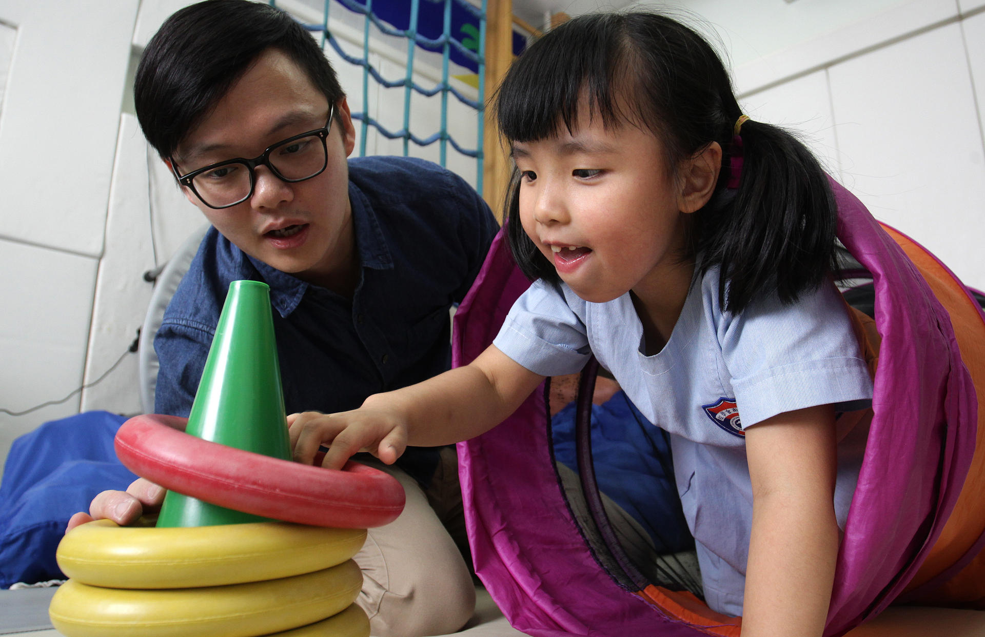 Occupational therapist Steve Chan (left) and six-year-old Sasa Lao at the Rainbow Project's learning centre on Sai Yuen Lane in Western. Photo: Dickson Lee