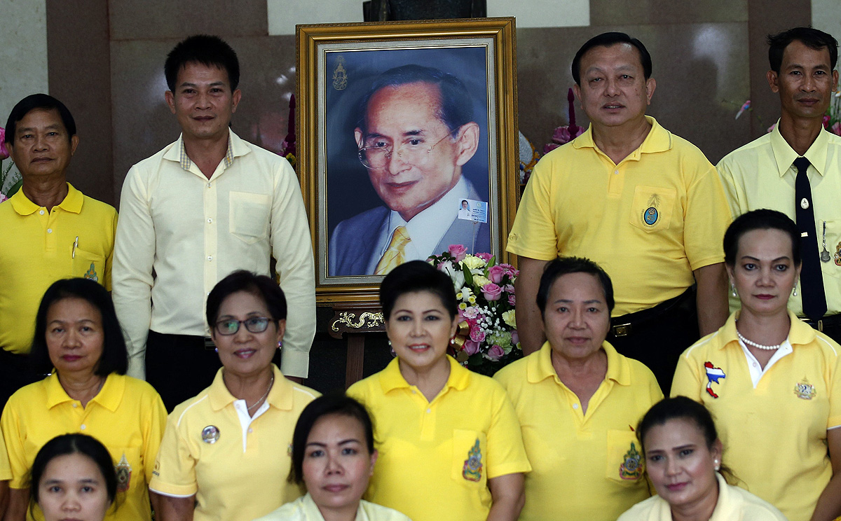 Thai well-wishers wearing yellow shirts in honour of the King Bhumibol Adulyadej, pose for a photo with a picture of the king at Siriraj Hospital in Bangkok on 14 November. Photo: EPA 
