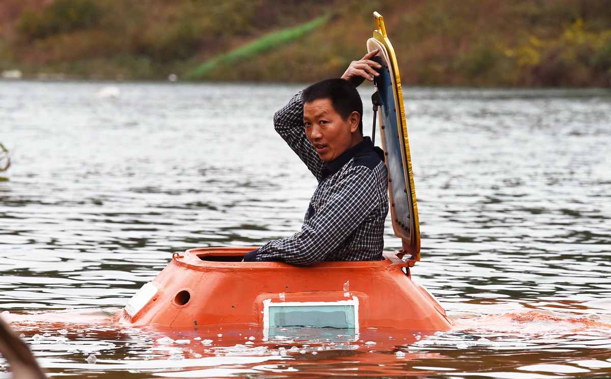 Farmer-turned-inventor Tan Yong in his homemade orange submarine. Photo: AFP