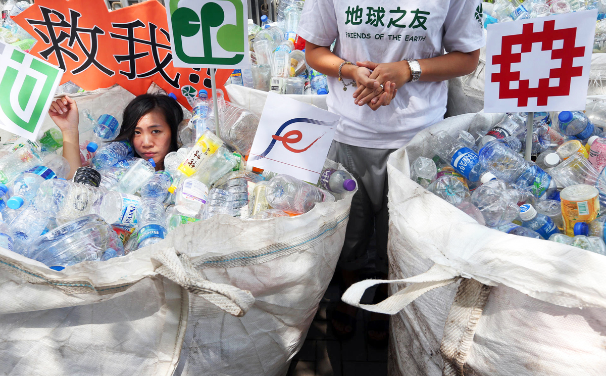 Celia Fung battles with more than 1,000 plastic bottles left by protesters outside government headquarters in Tamar. Photo: Sam Tsang