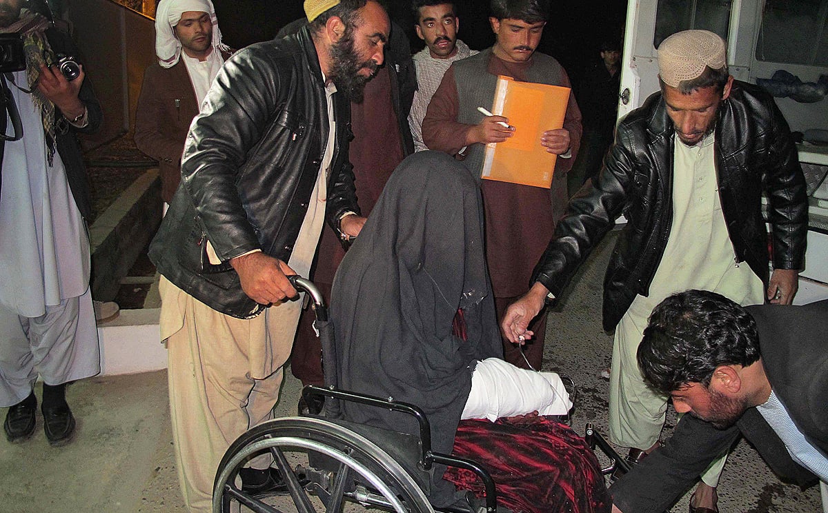 A  wounded Afghan woman in a wheelchair is brought to hospital in Helmand province after a rocket fired by Afghan forces killed at least 17 wedding guests. Photo: AFP