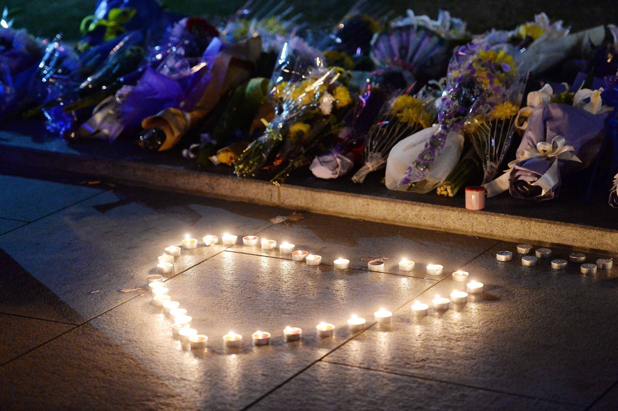 Candles and flowers are placed by mourners for the victims of the stampede, in front of the statue of the late Shanghai mayor Chen Yi near the stampede site on the Bund in Shanghai, China, late 01 January 2015. Photo: EPA