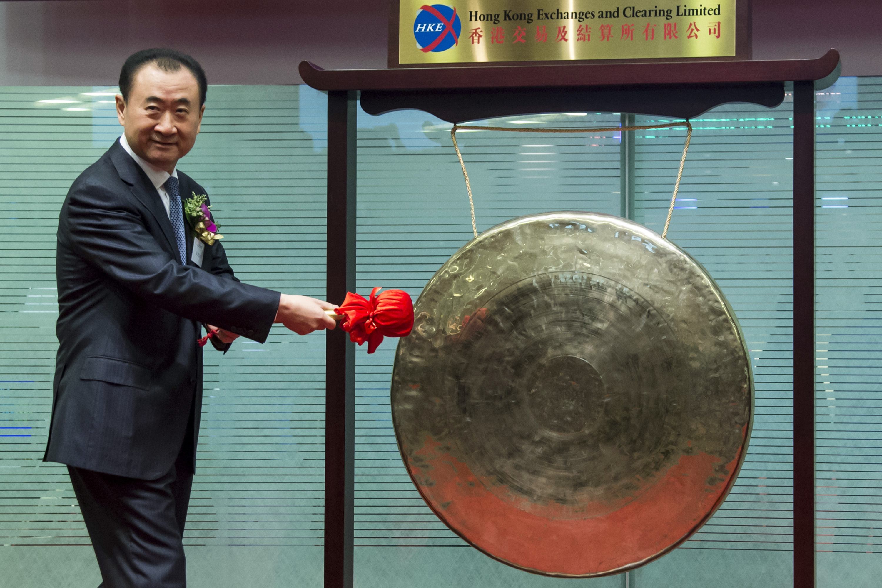 Wang Jianlin, chairman of Wanda commercial properties, hits a gong during the debut of the company in Hong Kong's stock exchange. Wanda E-commerce, its joint venture with Tencent and Baidu, saw its valuation soar to 20 billion yuan (HK$25.4 billion) Photo: Reuters