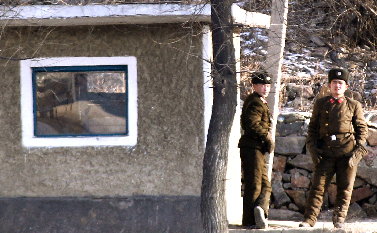 Two North Korean soldiers stand guard on the border with China. Photo: Simon Song