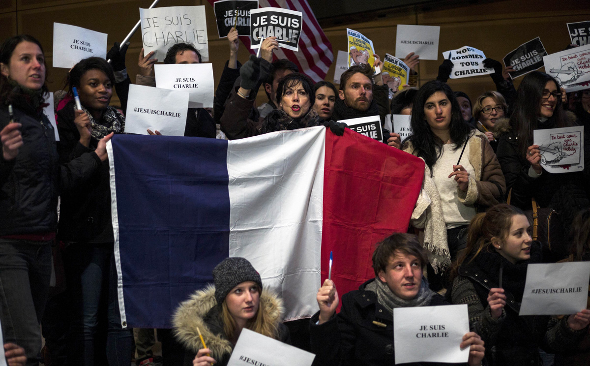 US citizens hold the French national flag and posters with the words "Je Suis Charlie" outside the Newseum in Washington on Wednesday in solidarity with the victims of the shooting at the Paris office of the satirical publication Charlie Hebdo. Photo: AFP