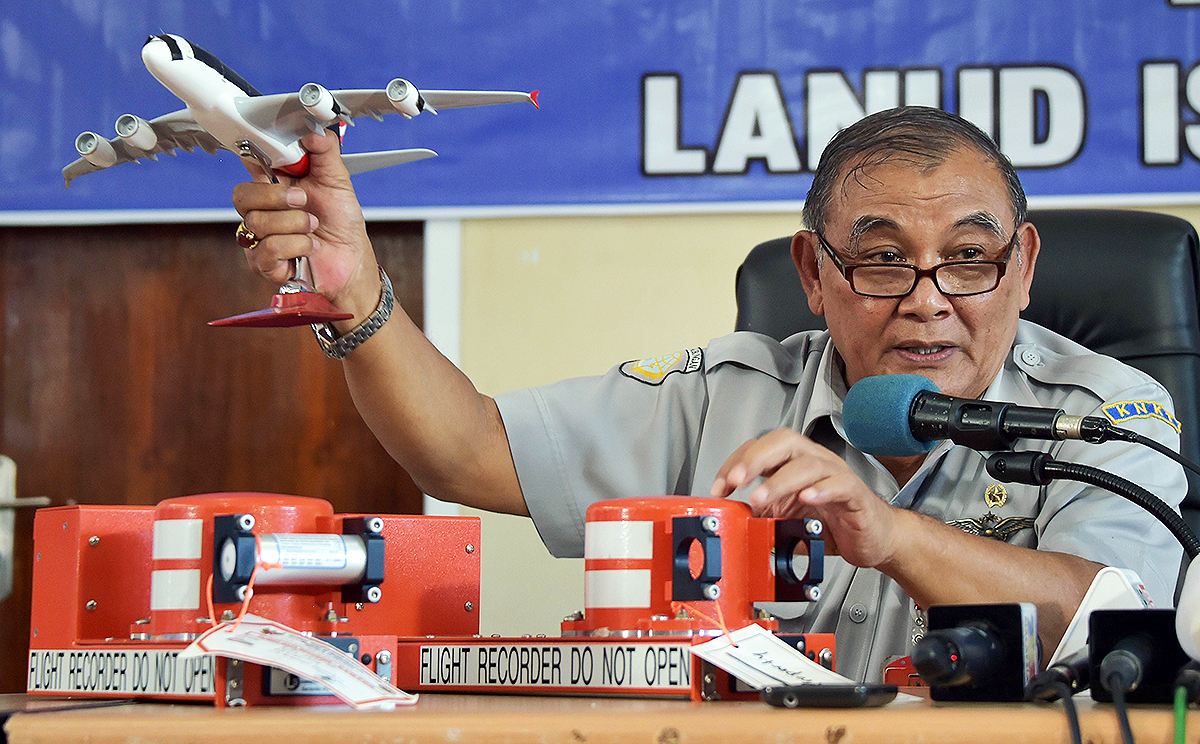 Tatang Kurniadi, the head of the National Transportation Safety Committee shows parts of the flight data recorder (right) and cockpit voice recorder at a press conference in Pangkalan Bun. Photo: AFP 