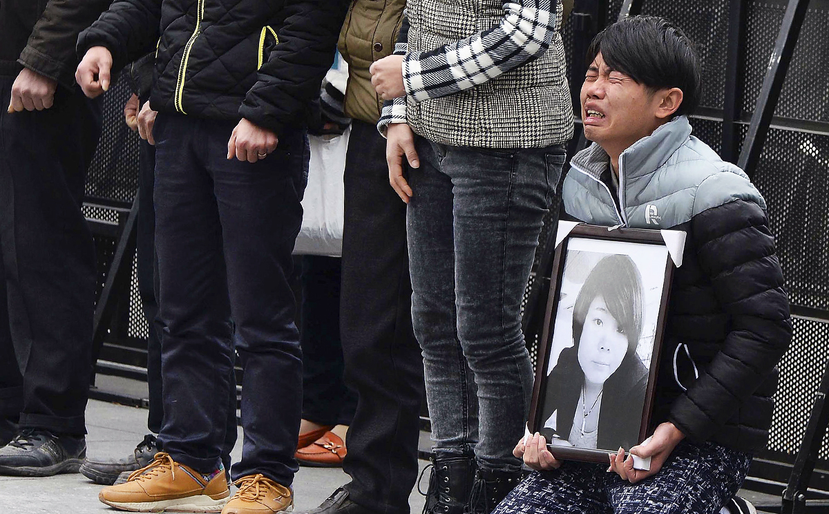 A man holds a portrait of a Shanghai stampede victim. Photo: AP