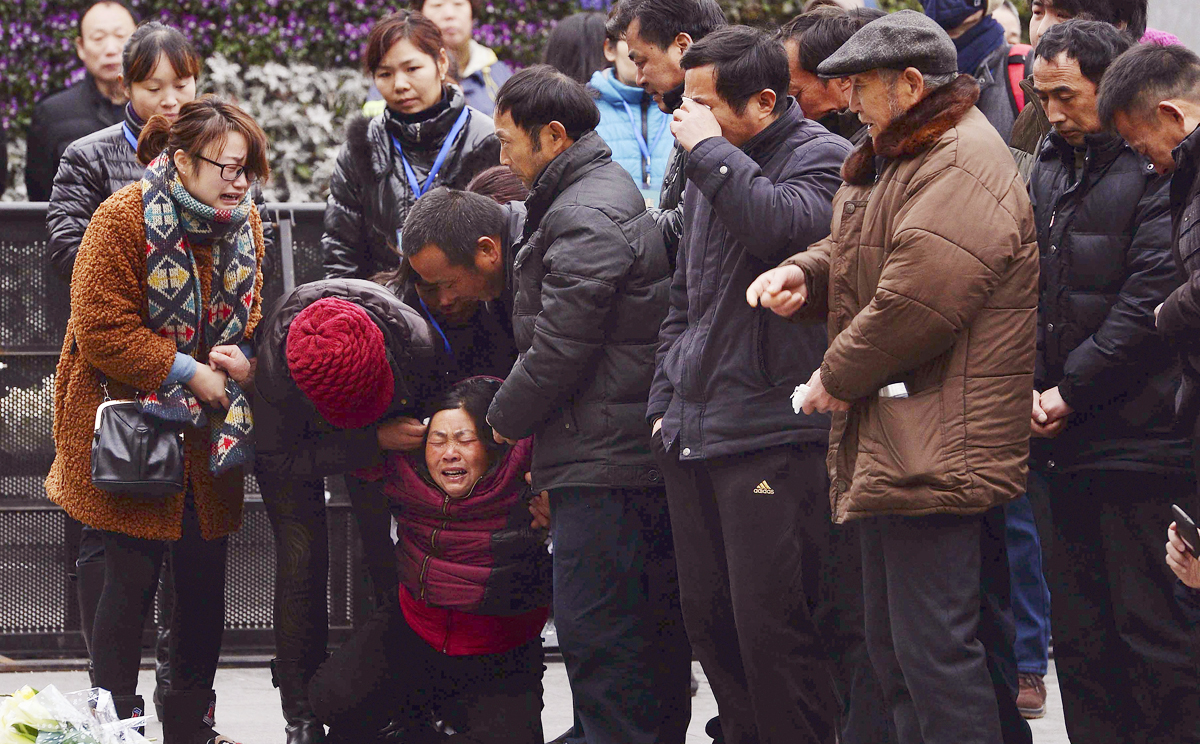 A woman (third left) grieves as she is comforted by other relatives of a New Year's Eve stampede victim. Photo: AP