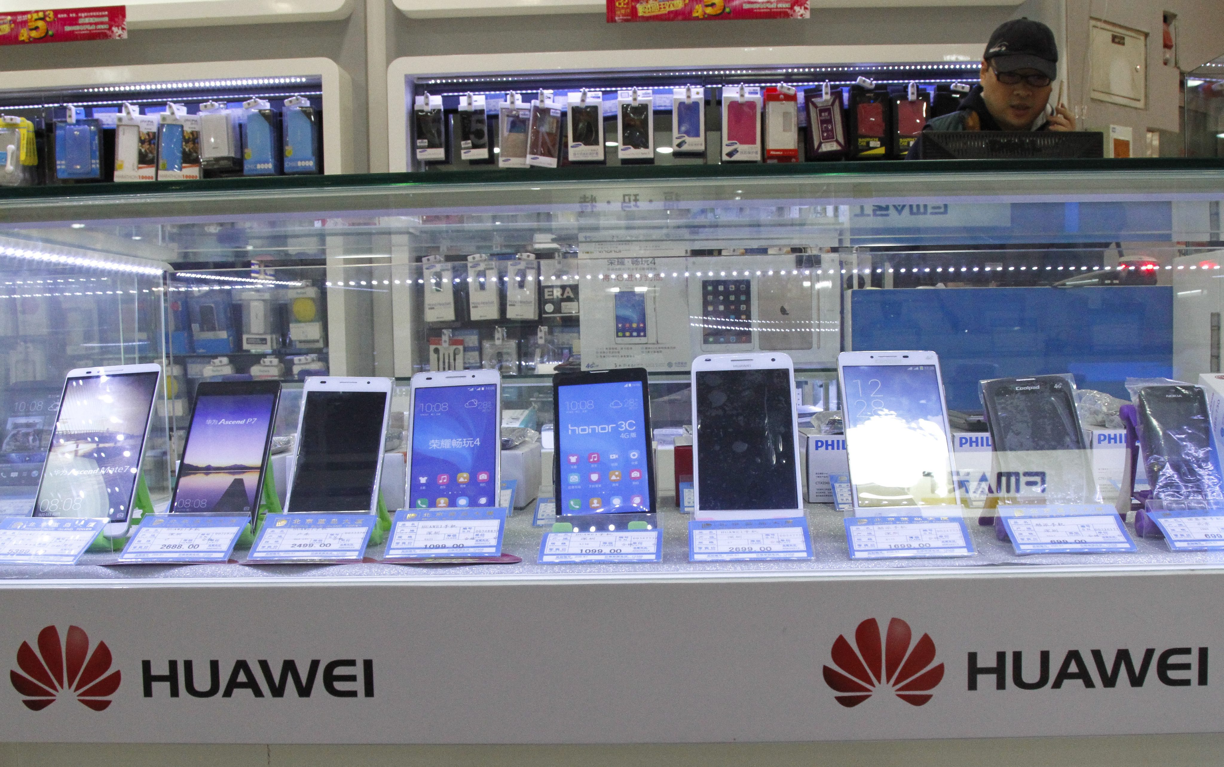 Huawei smartphone products are displayed for sale with other brands at a shopping mall in Beijing, China. Photo: EPA