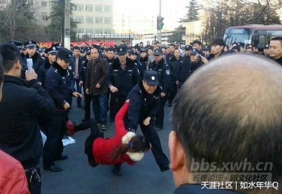 The photo shows a policeman lifted a woman by the collar and threw her on the pavement as dozens of fellow officers watched.