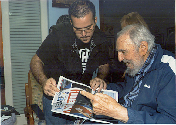 Former Cuban leader Fidel Castro (right) flips through a newspaper, seemingly amused. Photo: Reuters