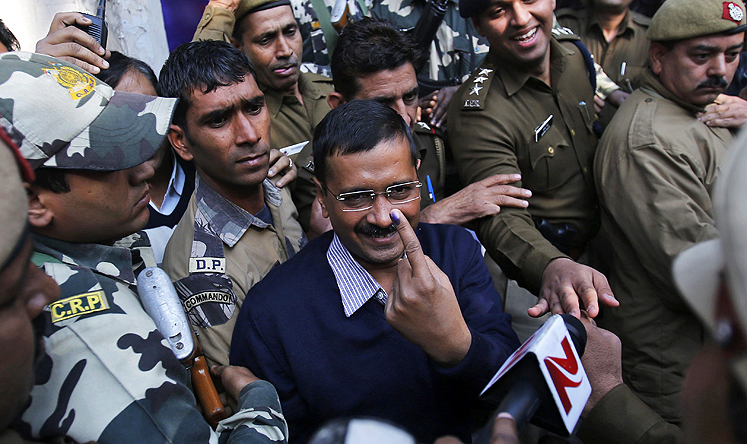 Aam Aadmi Party chief and ministerial candidate for Delhi, Arvind Kejriwal (centre) shows his ink-marked finger after casting his vote on Saturday. Photo: Reuters