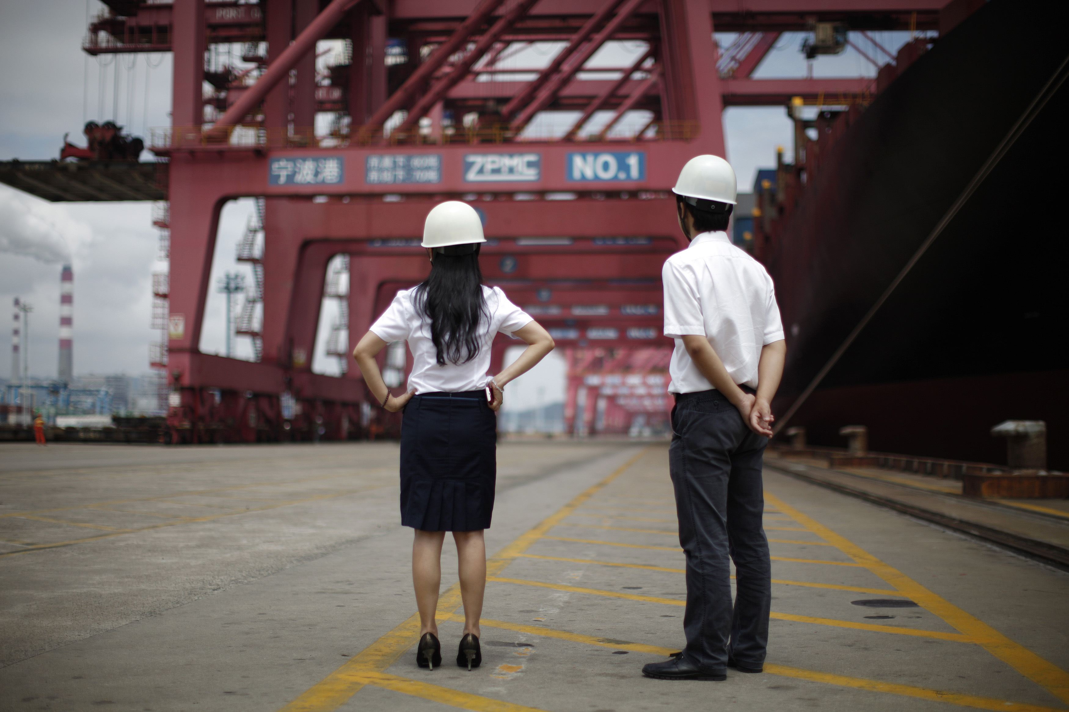Employees watch goods being loaded for export in a port in China. Photo: Reuters