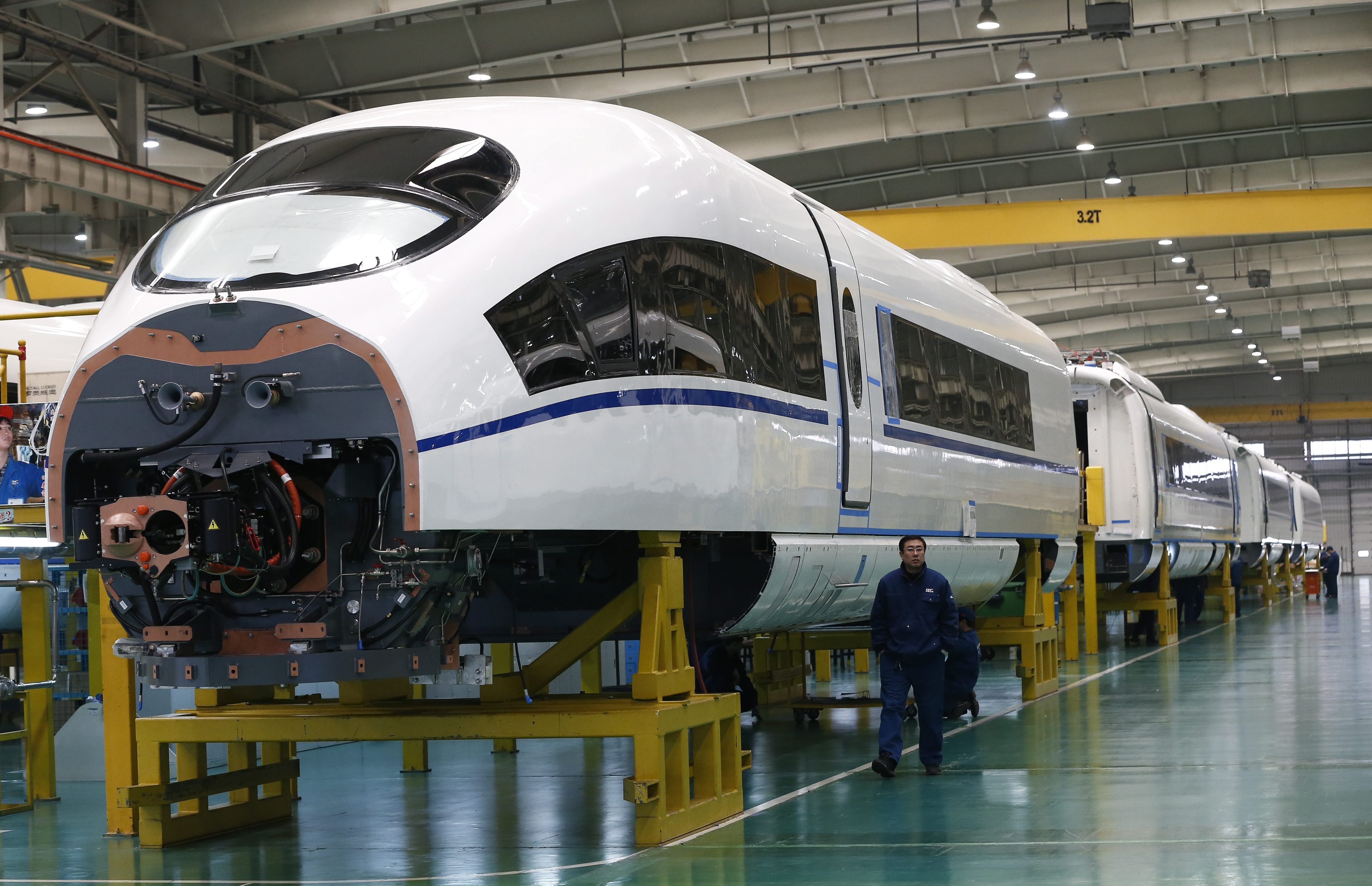 Worker passes by almost completed high-speed train in Tangshan city in Hebei province in China. Photo: EPA  