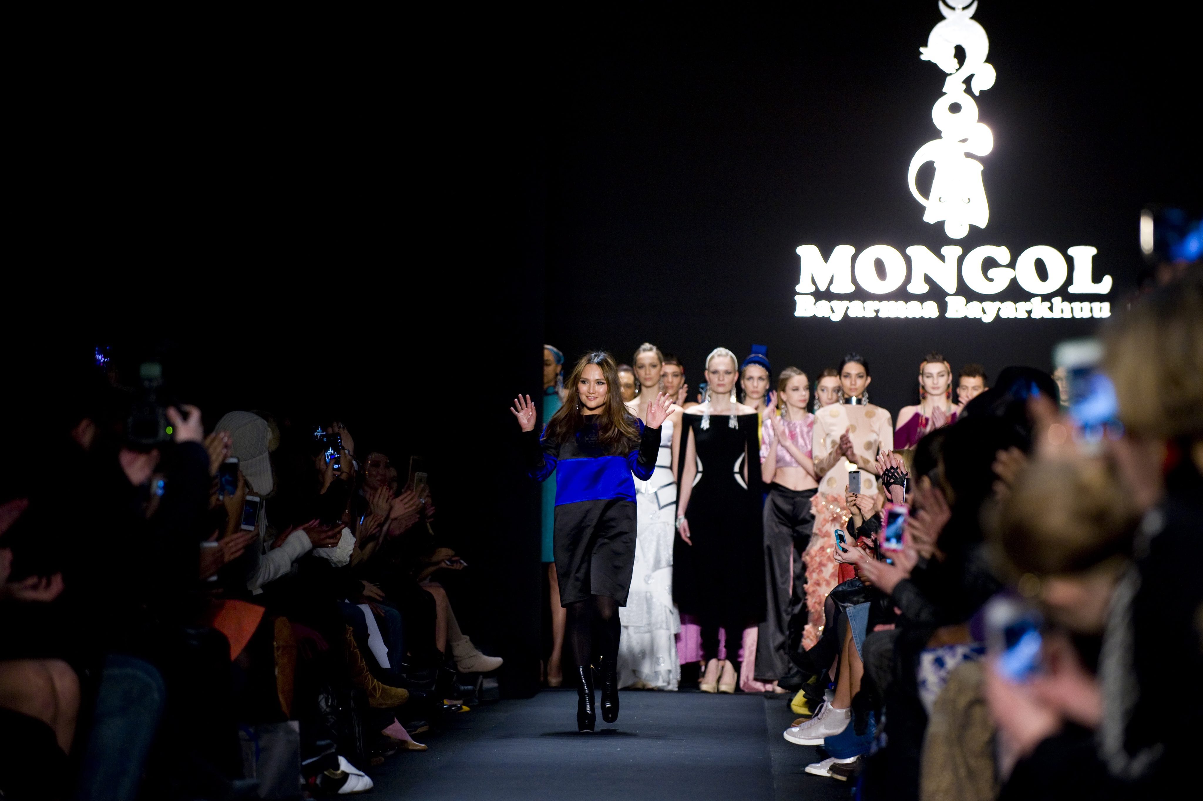 Bayarmaa Bayarkhuu waves on the catwalk after the show for her label Mongol in New York. Photo. EPA