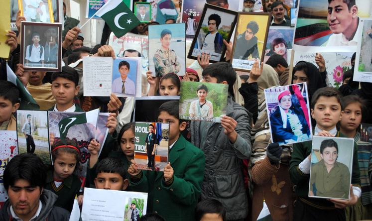 Students hold photographs of fellow pupils killed in a Taliban attack on the Army Public School in Peshawar, northwest Pakistan, in December. Photo: Xinhua