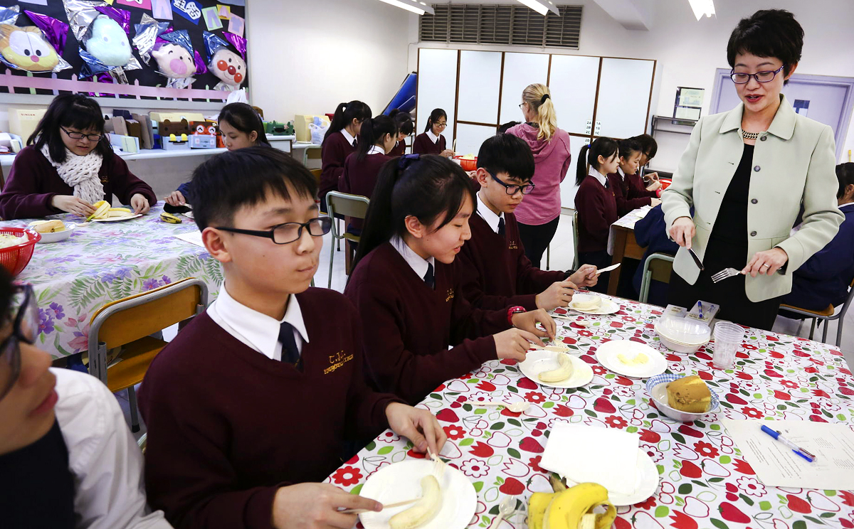 Bernice Lee, founder of the Etiquette and Leadership Institute, shows students how to use a knife and fork. Photo: Jonathan Wong