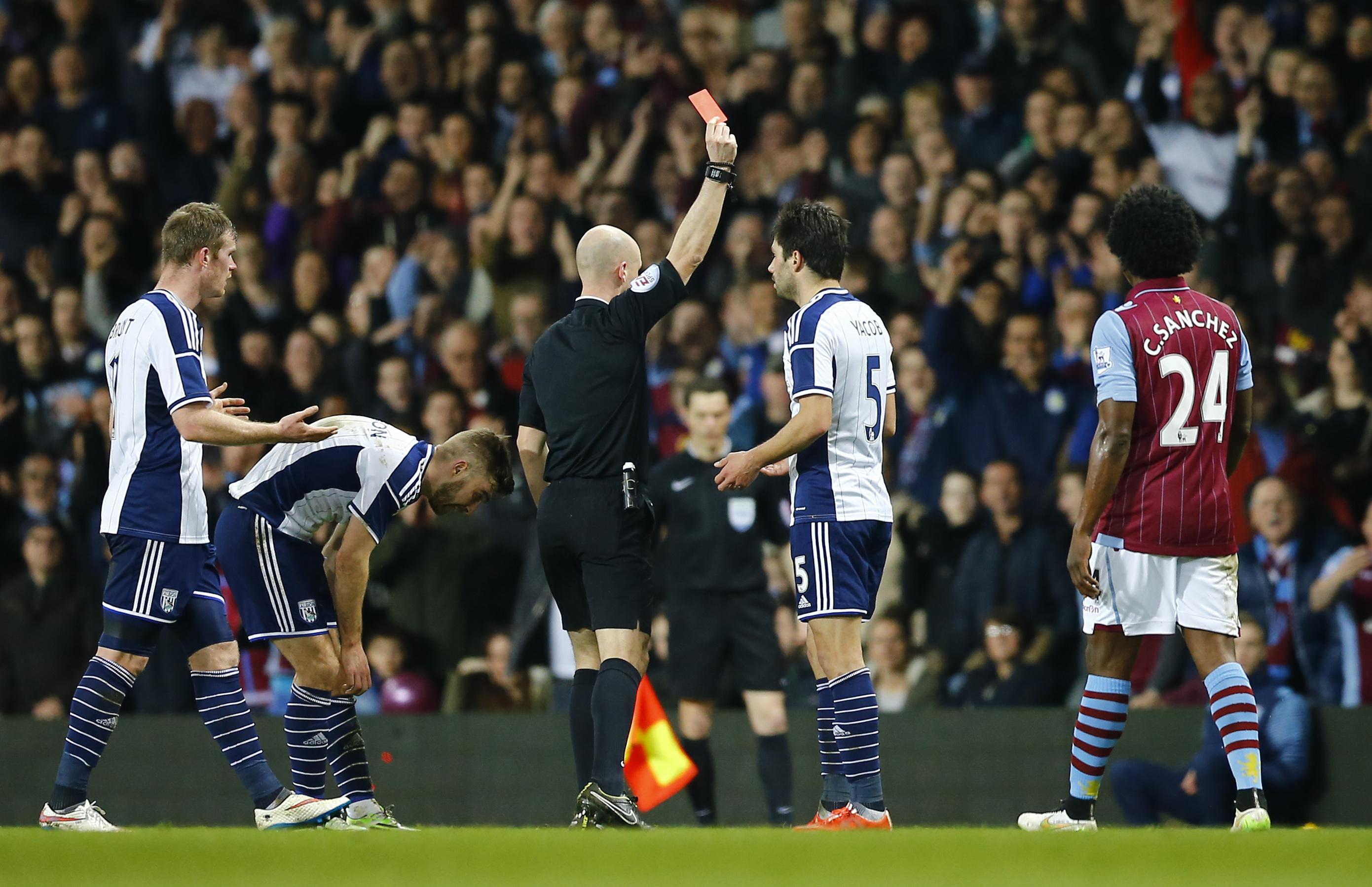 Referee Anthony Taylor sends off West Brom's Claudio Jacob. Colour psycghology suggests black shirts command discipline. Photo: Reuters 