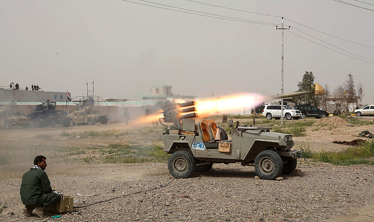 A fighter with an Iraqi Shiite militant group launches rockets against Islamic State positions in Tikrit on Friday. Photo: AP