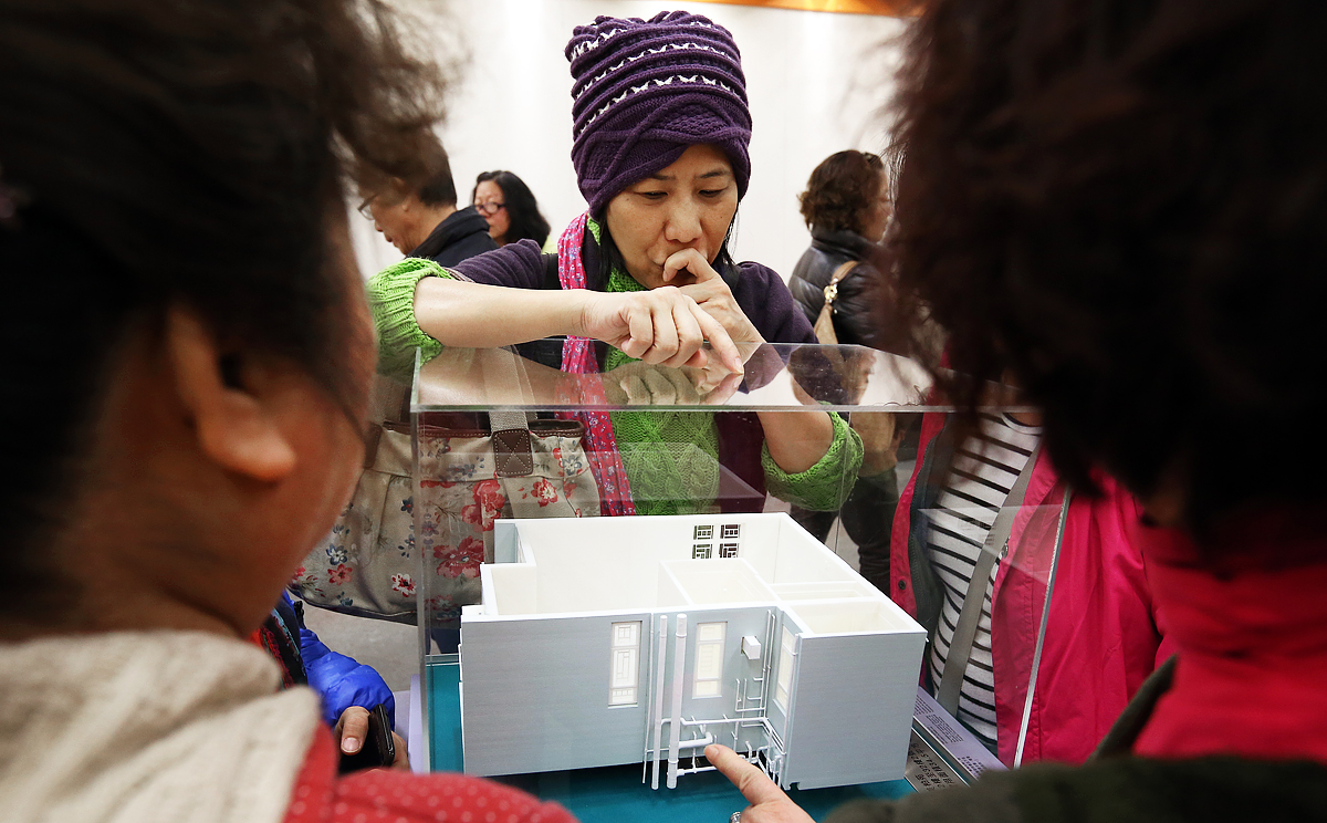 People watch the models of new HOS flats during the first day's application at Hong Kong Housing Authority Customer Service Centre in Lok Fu in December, 2014. Photo: Nora Tam