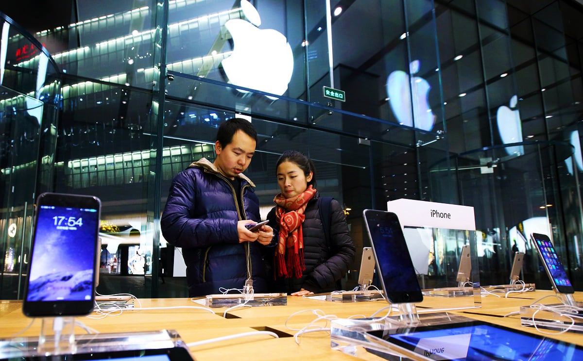 A couple look at an Apple iPhone 6 at an Apple store in the China Central Mall in Beijing, China. Photo: Bloomberg