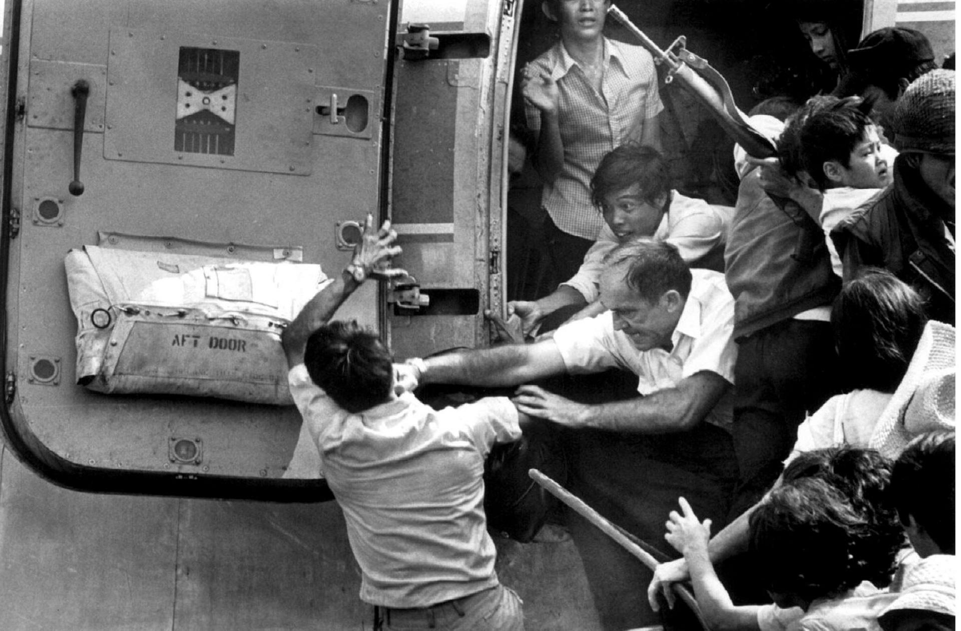 An American official punches a man (left) in the face as he tries to close the door of a plane loaded with refugees trying to escape the Vietcong advance towards Saigon. The city fell on April 30, 1975. Photo: Reuters