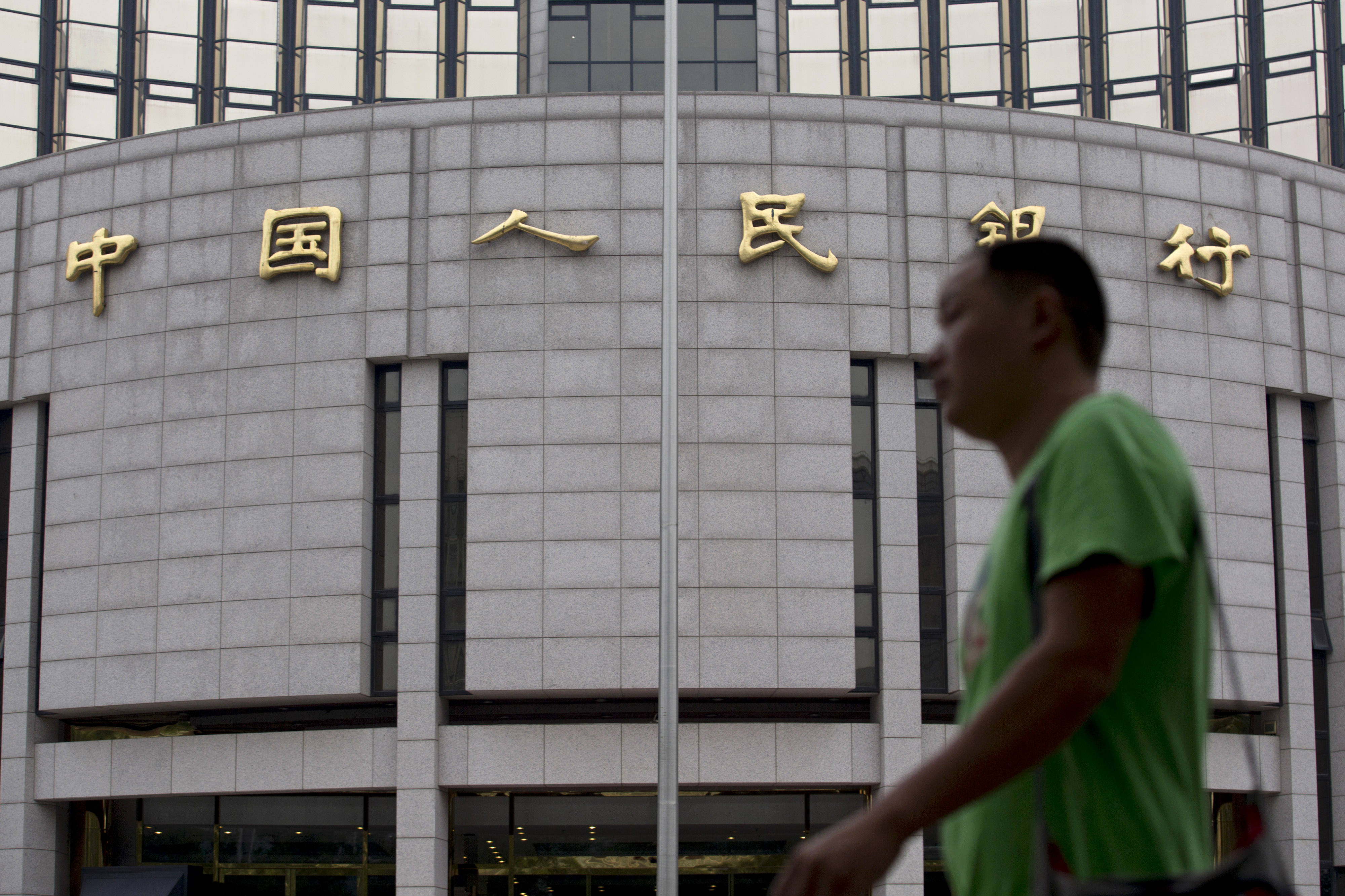 People's Bank of China building in Beijing looms in the background of a passersby. Photo: Bloomberg