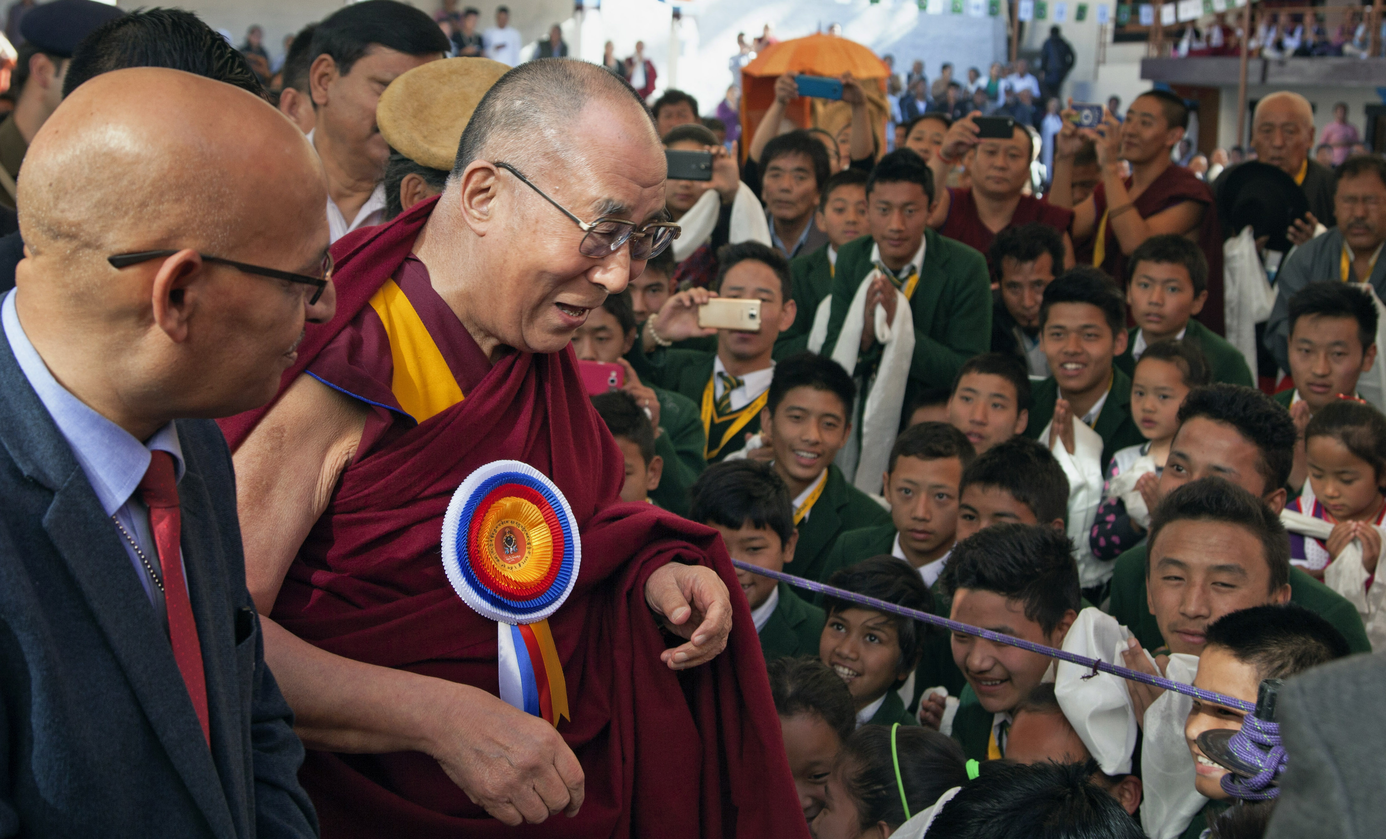 The Dalai Lama is welcomed by schoolchildren upon his arrival at the Tibetan Institute of Performing Arts in Dharmsala, India. Photo: AP