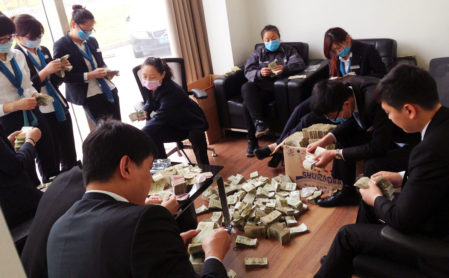 Chinese employees count bundles of one-yuan and 50-cent banknotes paid by a Chinese buyer for a car at a BMW dealership in Zhengzhou city, Henan province. Photo: AFP/ ImagineChina
