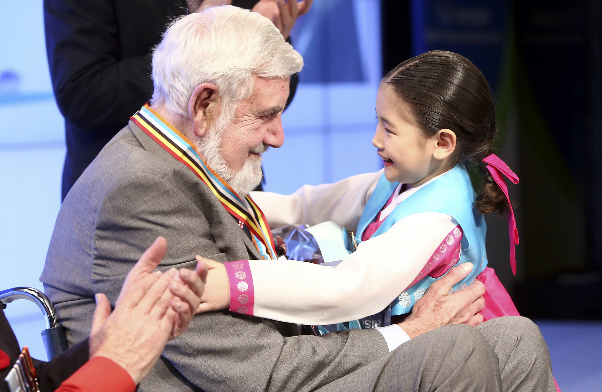 Korean War hero Bill Speakman, 87, is greeted by a young South Korean girl during the presentation ceremony for his medals. Speakman said the medal originated in South Korea, so it should be returned there. Photo: Lee Dong-geun